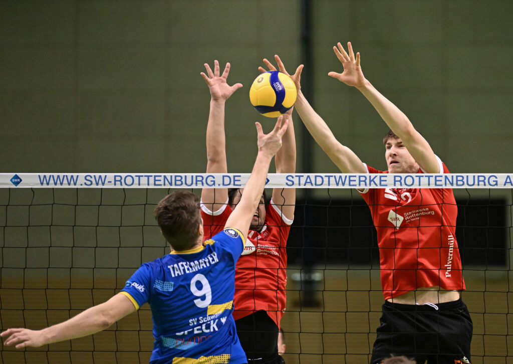 Volleyball 2. Bundesliga Süd, TV Rottenburg - SV Schwaig, 18.02.2023 - vorne Flortian Tafelmayer (Schwaig) im Block Oliver Knobelspiess (links) und Jan Huber (rechts, beide TVR)Foto: Axel Grundler