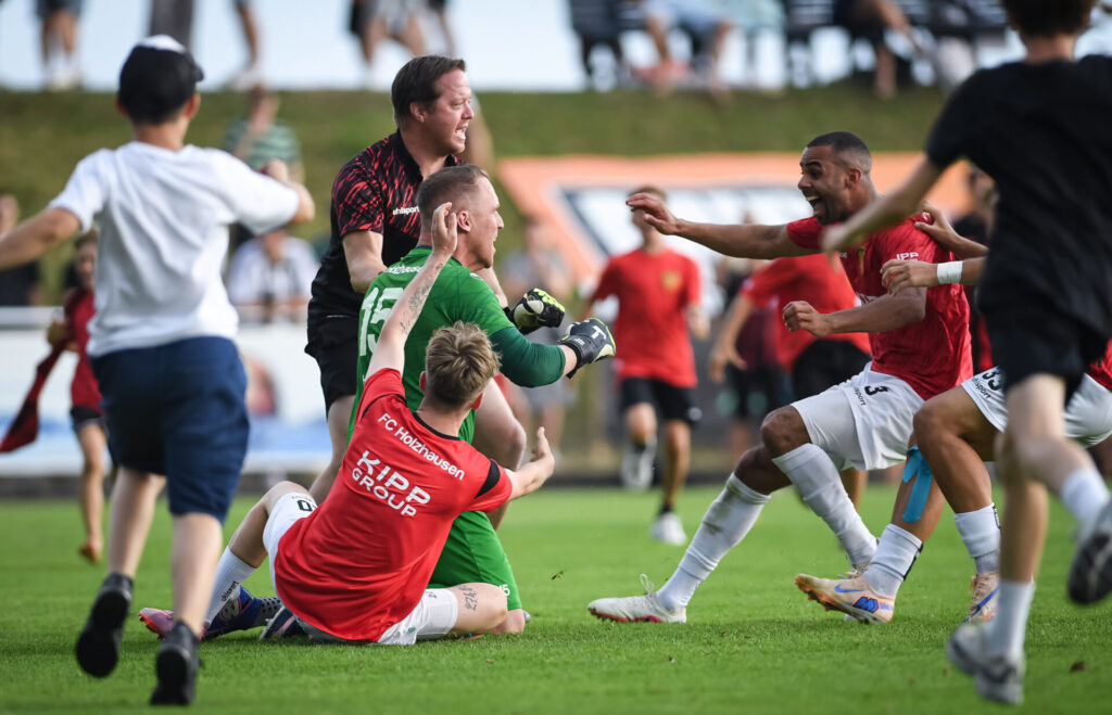Fussball Verbandsliga  2025 /2026   21.06.2026 Relegation zur Oberliga Baden - Wuerttemberg FC Holzhausen - SC Lahr Elfmeterschiessen, JUBEL FC Holzhausen; Torwart Julian Hauser (li)  haelt einen Elfer des SC Lahr, somit steigt der FC Holzhausen auf und jubelt hier mit und Julio Leitao Gourgel (re) und FansFOTO: Pressefoto ULMER xxNOxMODELxRELEASExx